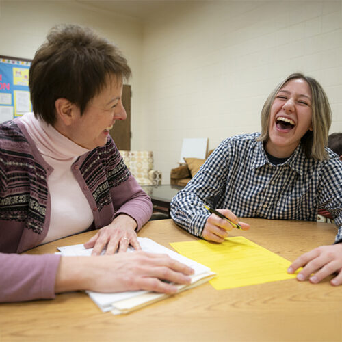 A professor and student share a laugh