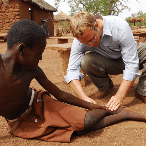 Adam Weiss, helping a patient suffering with Guinea worm.