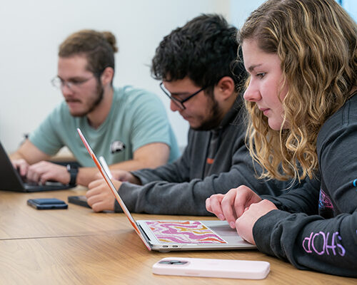 Three students work on a group project