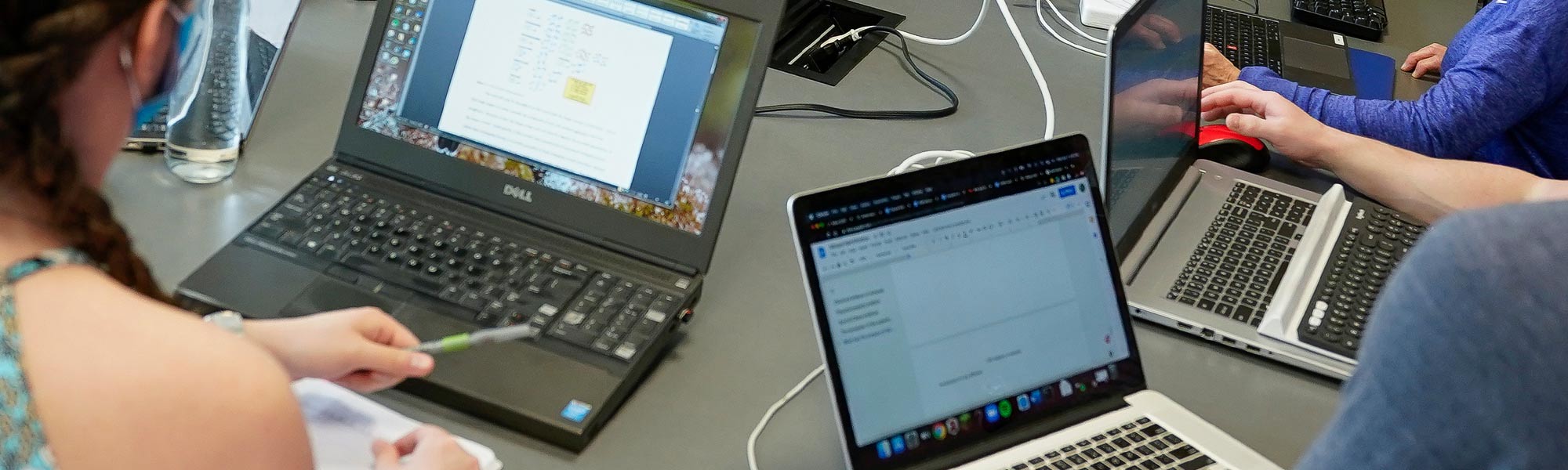 A group of students use many laptops