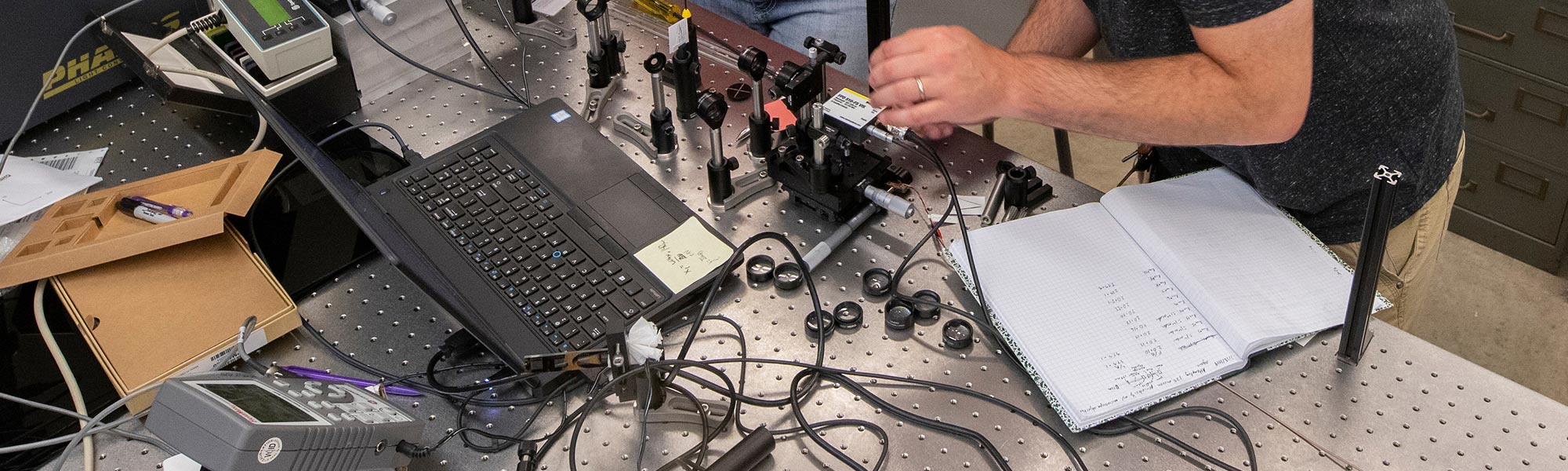 Students and professor work on physics tools