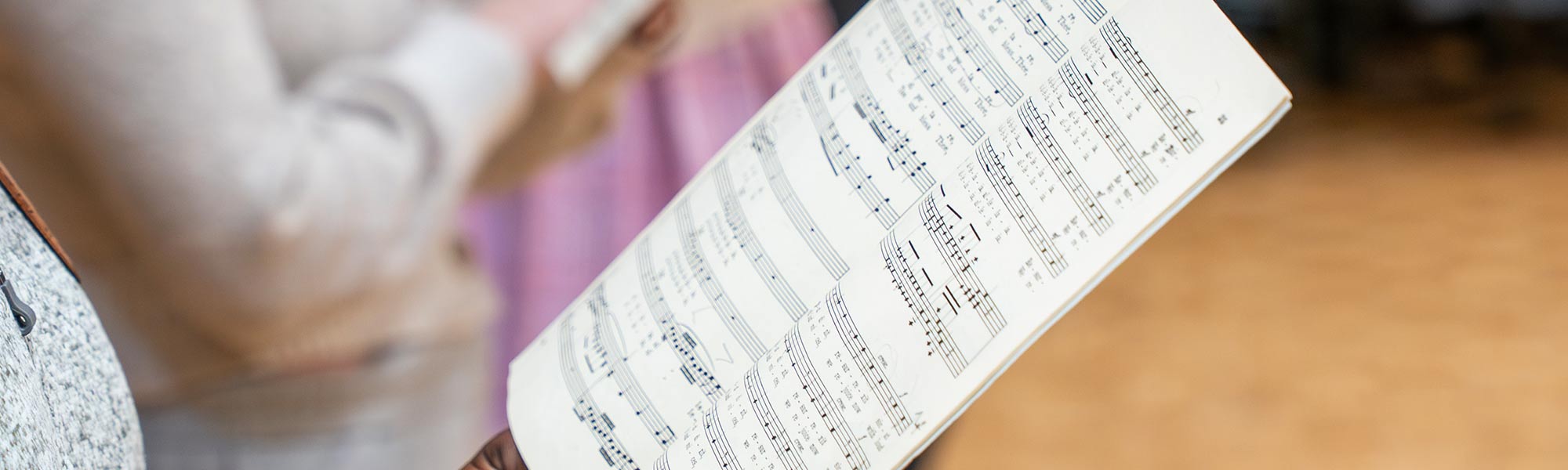 A student sings music from sheet music