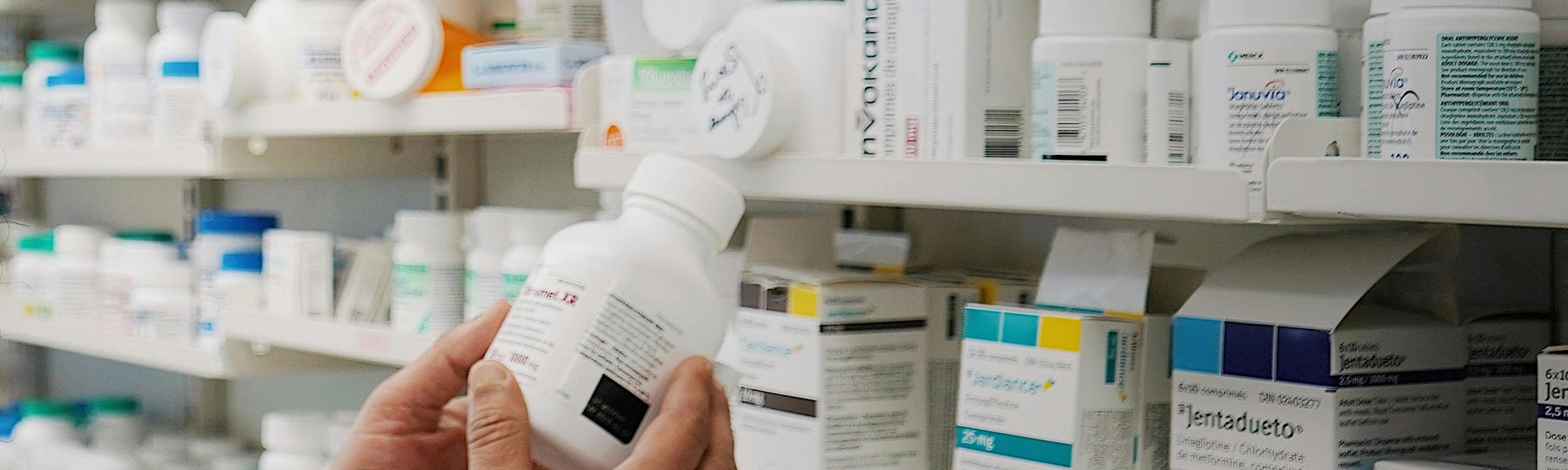 Someone selects medication. Photo by World Sikh Organization of Canada: https://www.pexels.com/photo/pharmacist-in-front-of-shelves-with-medicines-14797855/