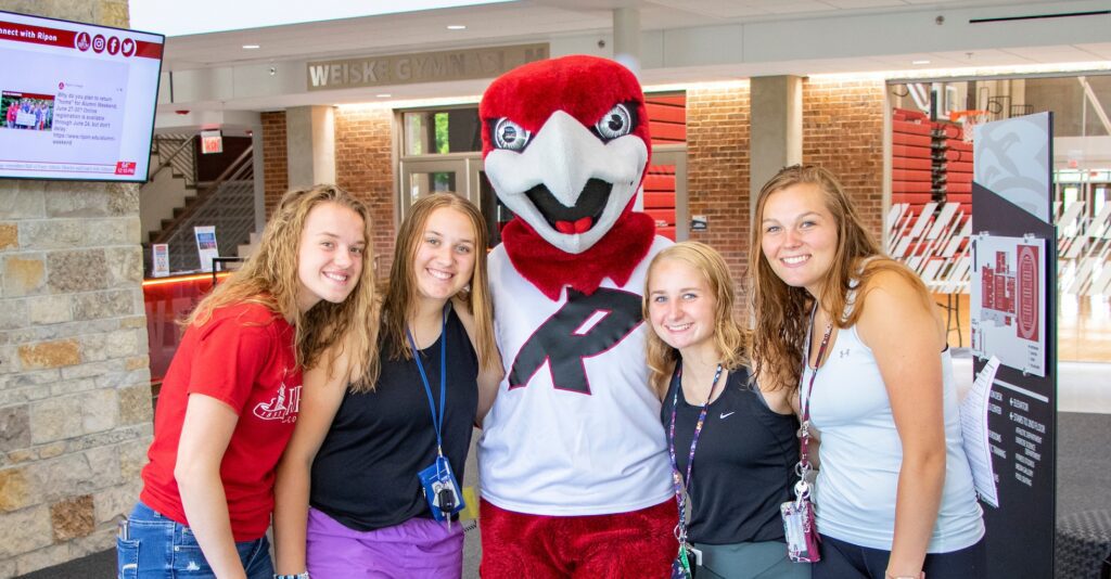 4 girls take picture with Rally at Summer Orientation event at Ripon College.