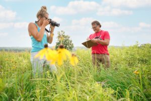 Gemma Krause and Assistant Professor of Biology Ben Grady document bees in Ceresco Prairie Conservancy as part of Summer Opportunities for Advanced Research (SOAR)