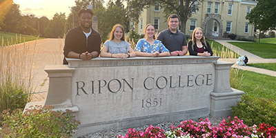 Four students in student government pose in front of Ripon College