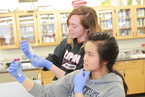 Two female students conducting experiment in chemistry lab