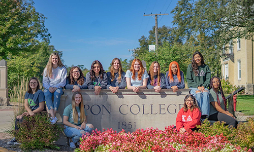 Kappa Delta sorority members pose for a group picture in front of the Ripon College campus on a sunny day