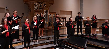 A group sings in front of a historic organ