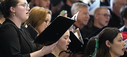 people of all ages sing in a large choir