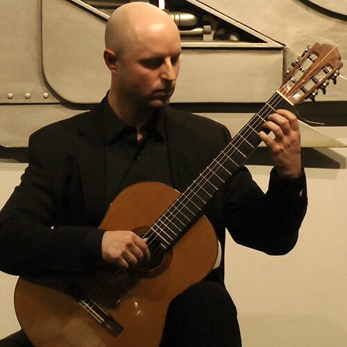 Adjunct Instructor of Music Christopher Cramer playing guitar
