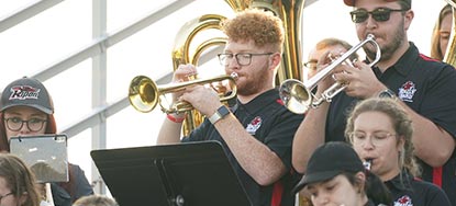 Students play various horns and wind instruments to get the crowd excited