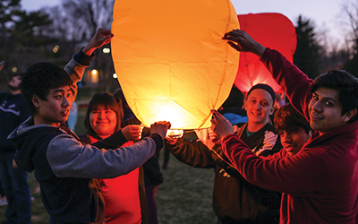 A group of Ripon College students hold Chinese lanterns, preparing to release into the night sky
