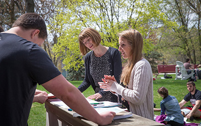 Associate Dean for Faculty Development and Professor of History Rebecca Matzke works with a group of students during an outdoor class on campus