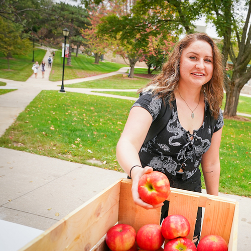 Student grabs apple from crate on her way to class on the Ripon College campus