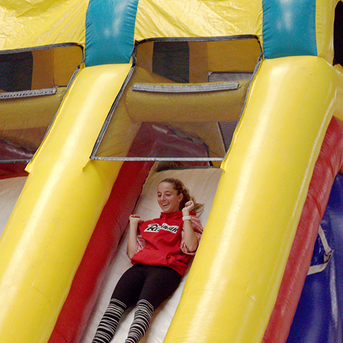 Student slides down inflatable slide at Rec and Roll event in Willmore Center