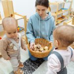 Mother and toddler twins playing with wooden and felt montessori toys in basket