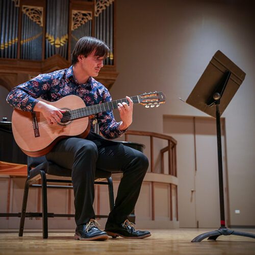 Isaac Tomaschefsky '24 playing the guitar on stage