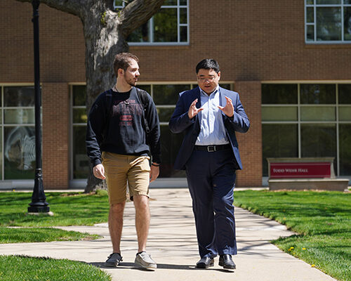 A student and professor walking together