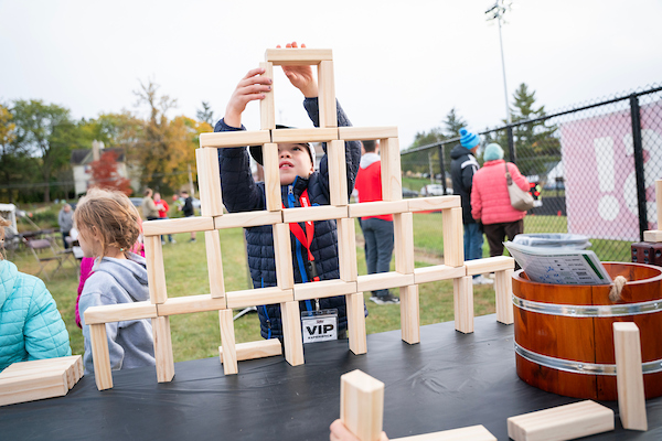 A child Stacks blocks at the homecoming tailgate