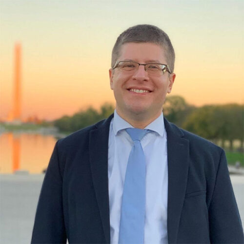 Speaker for CPP stands in front of a sunset