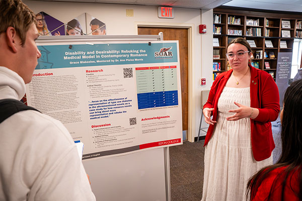 A student presents their poster to students