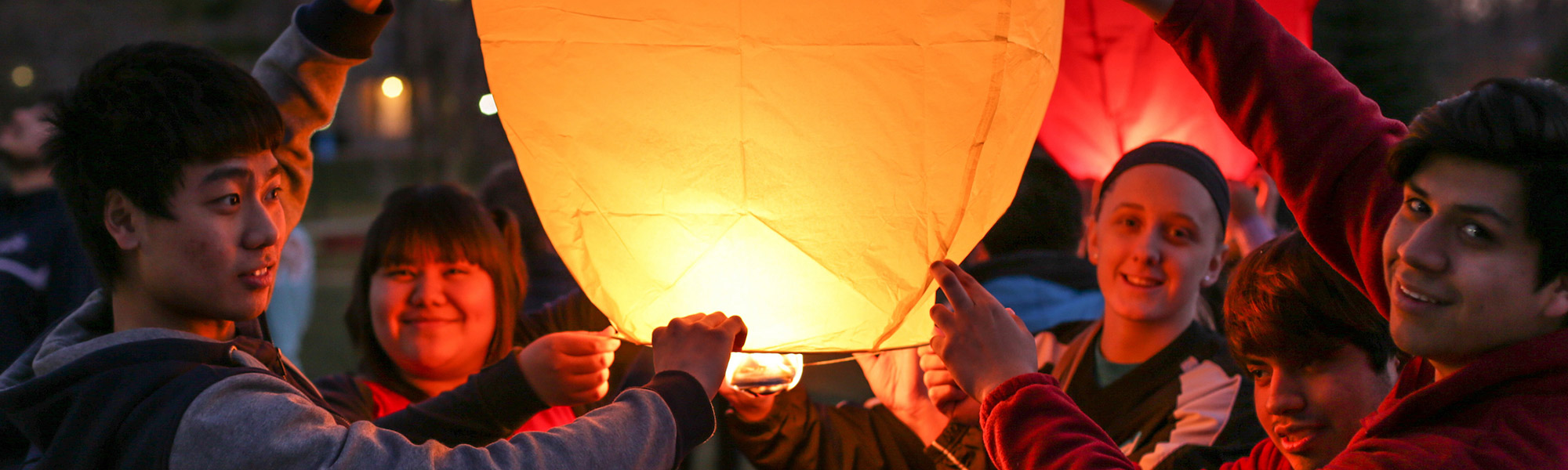 Students gather to hold a lantern