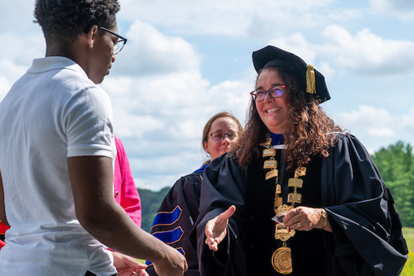 President Folse shakes a students hand
