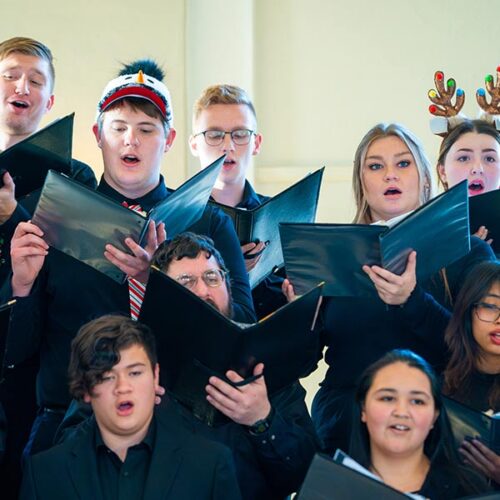 Festive singers in fun hats and much merriment.