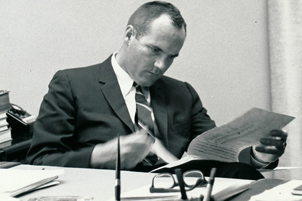Bernard reads notes with his glasses on the table