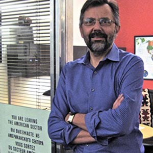 Mark stands with his arms crossed in his LA times office