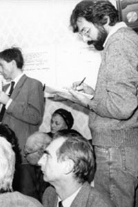Mark in a crowded press room taking notes