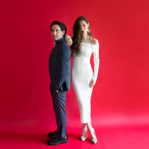 Two musicians on a bright red background
