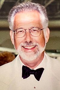 Morris in a white suit and bow tie