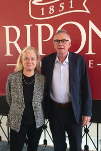 Yerkey and wife stand in front of a large Ripon College Banner