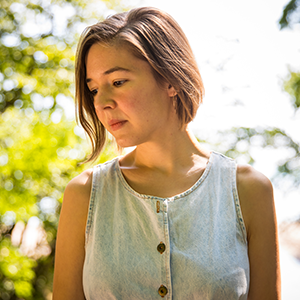 Alicia standing in sunlight and foliage
