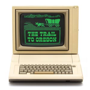 A very old school computer with the title of the play on the screen.