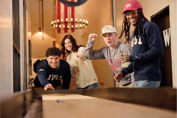 A group of students play shuffleboard at Knuths.