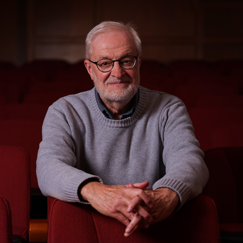 Music professor sitting in theatre seating