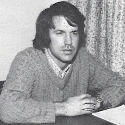 Tom Oyster sits at a desk.