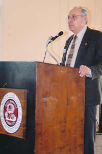 William Shang speaking at a podium in Great Hall. 