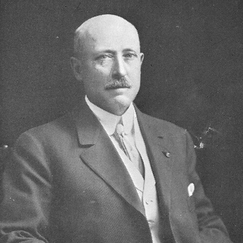 Kennan sitting in a suit and tie.