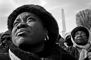A woman with tears in her eyes watches from Washington.