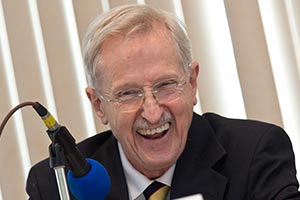 Hannaford laughing in front of a microphone. 