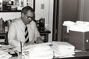 Doug sitting at a large desk.