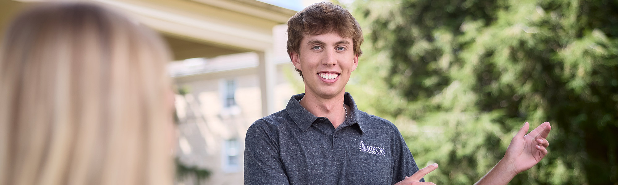 A student ambassador points to a direction on a tour