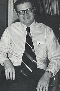 Wooley sitting in a chair with a tie on.