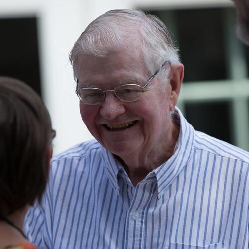 A smiling man in a striped shirt at Alumni Weekend