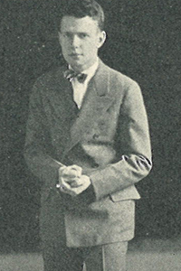 Brameld speaking in a debate as he pounds his fist to is open palm.
