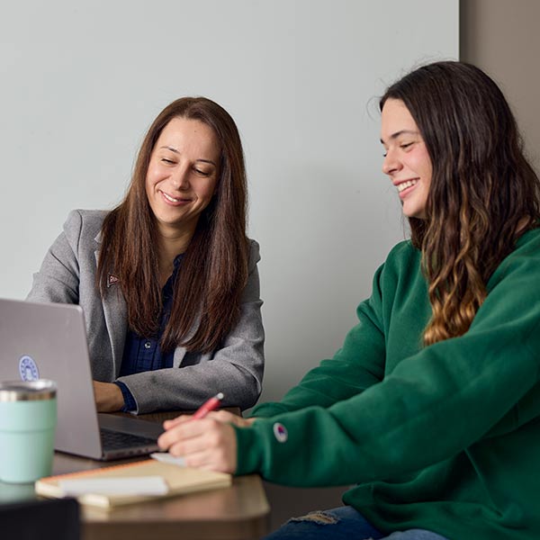 Student and professor look at a computer together